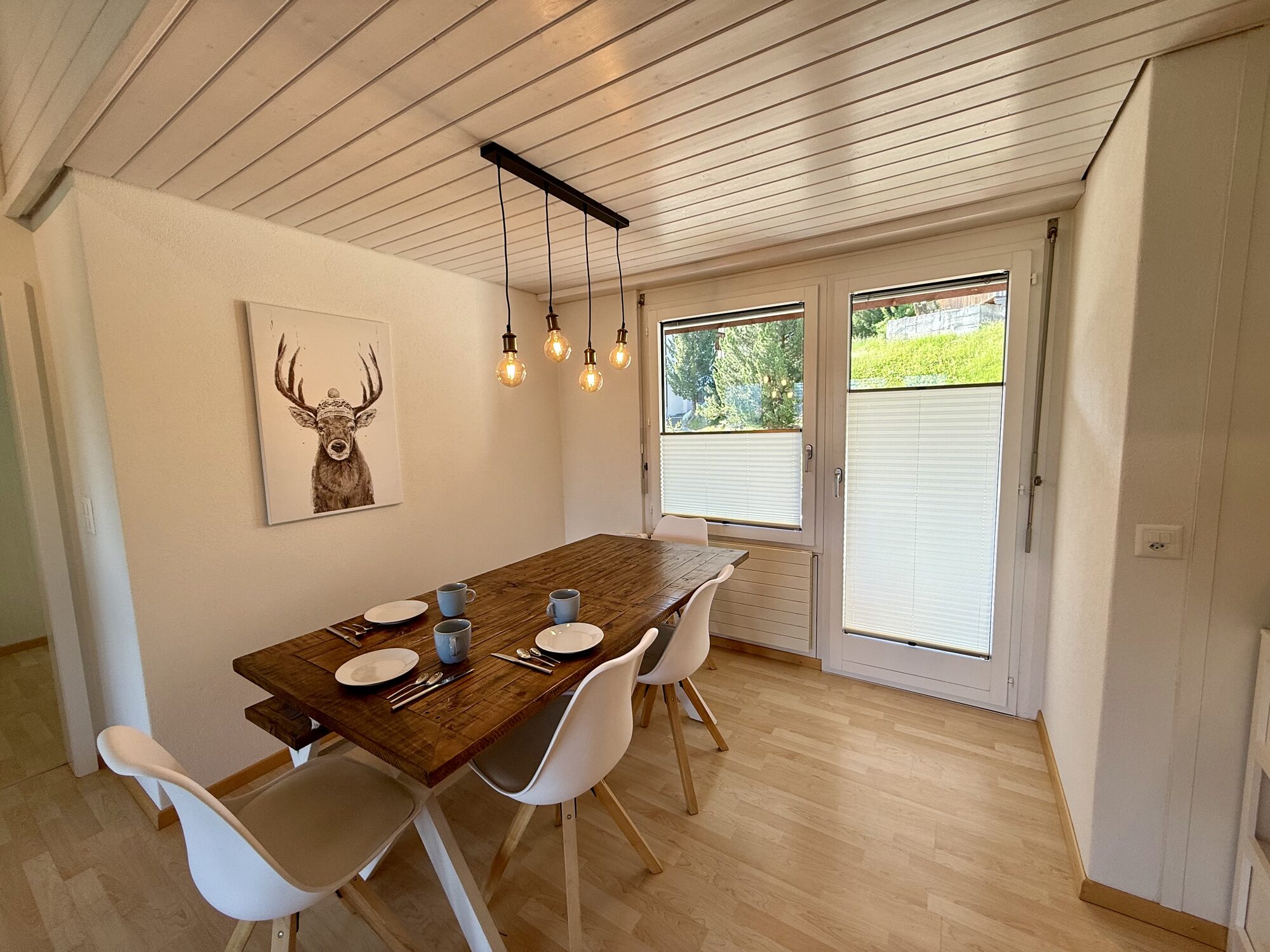 Esszimmer mit Holztisch und Pendelleuchten